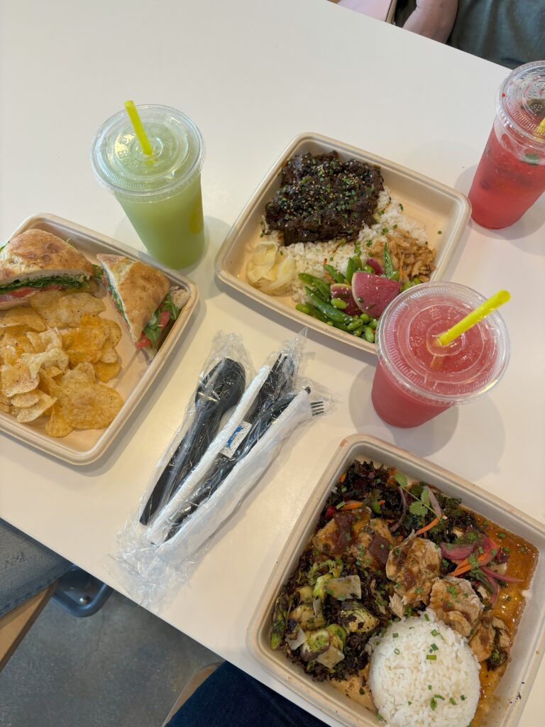 Three meals and three drinks on a table at Lemonade LA