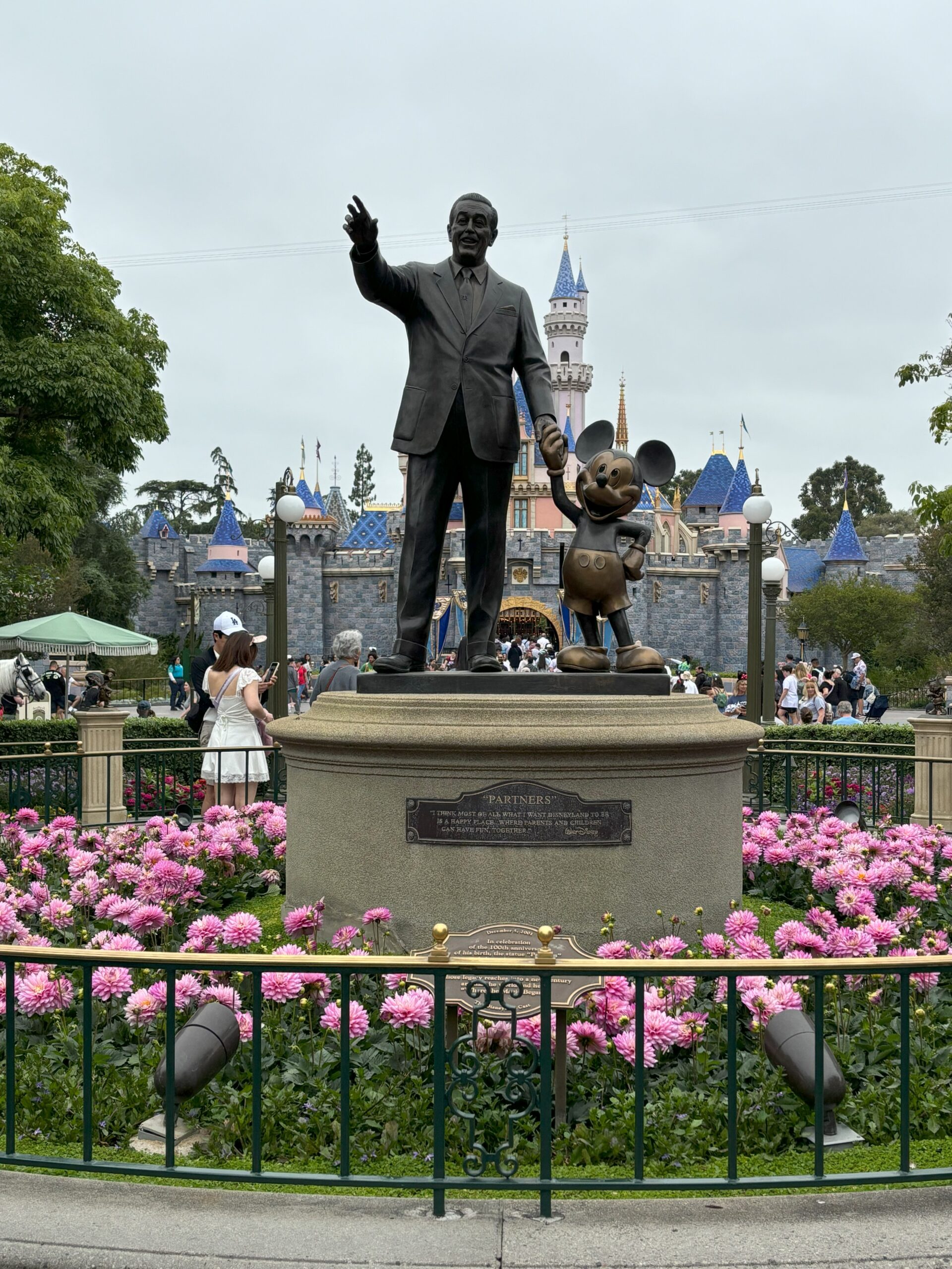 A picture of Walt Disney and Mickey in front of Cinderella's castle at Disneyland.
