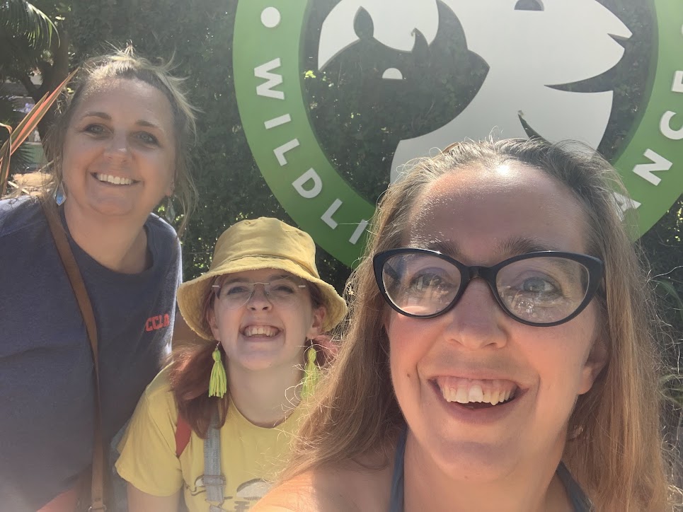Three women infront of a San Diego zoo sign