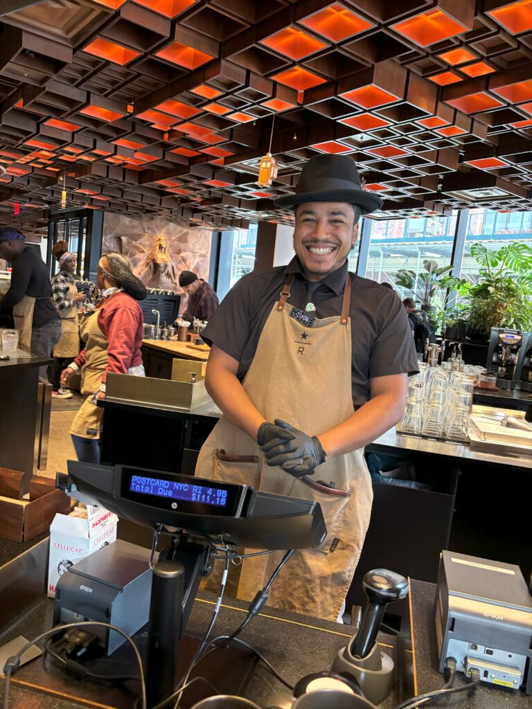 An employee standing at a register smiling
