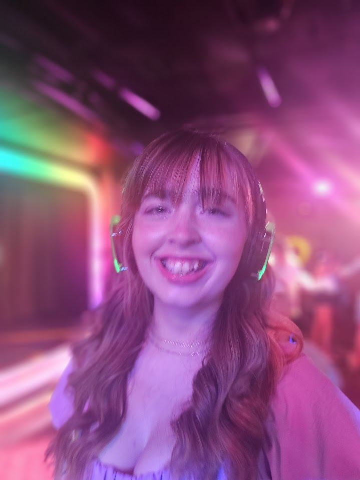 Breanna smiling with funky lights around her Disney World vs. Disney cruise