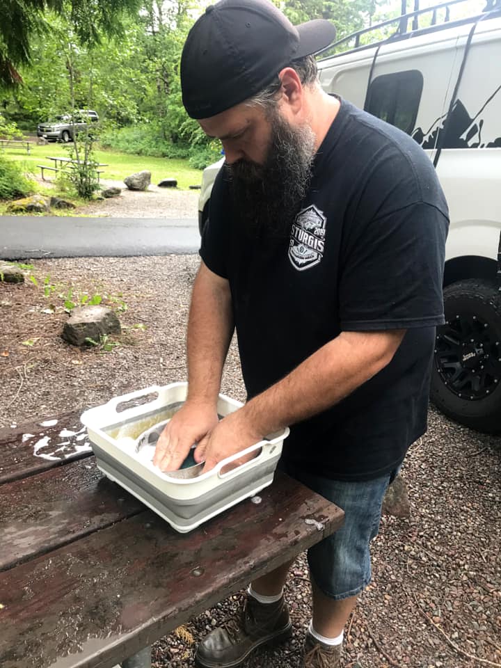 A man washing dishes when camping