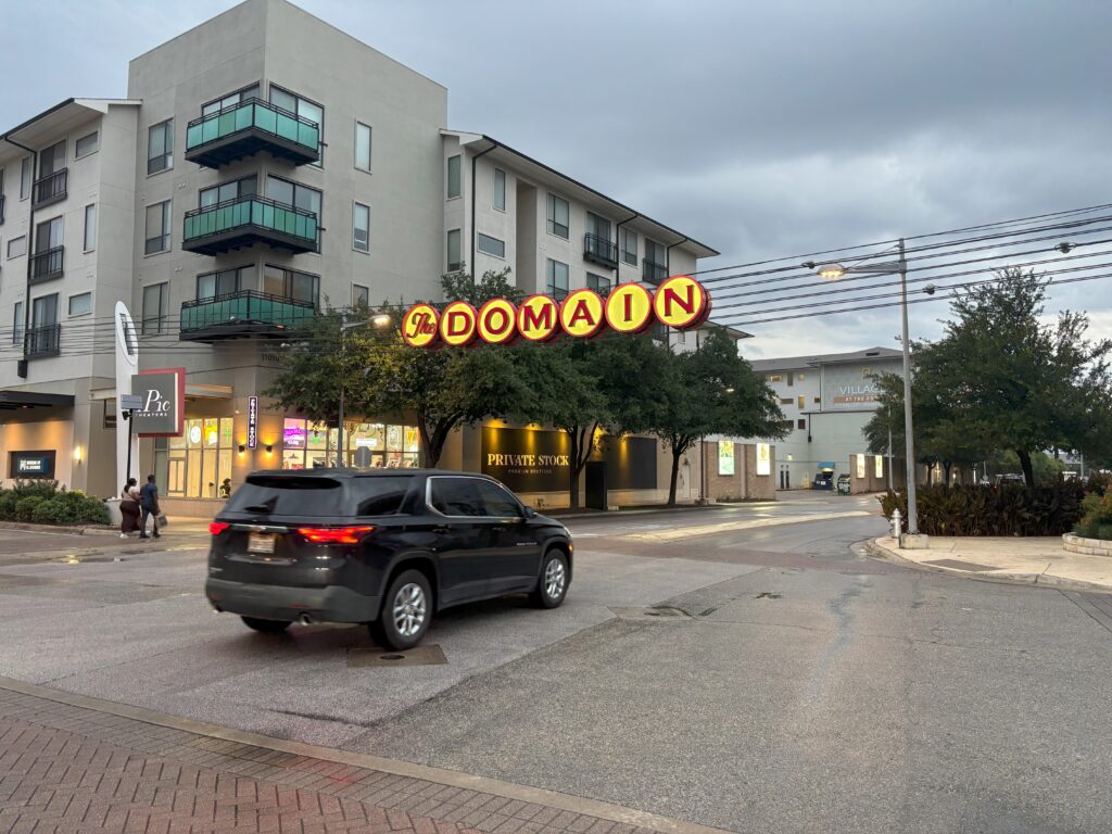 The domain sign with a car driving under it