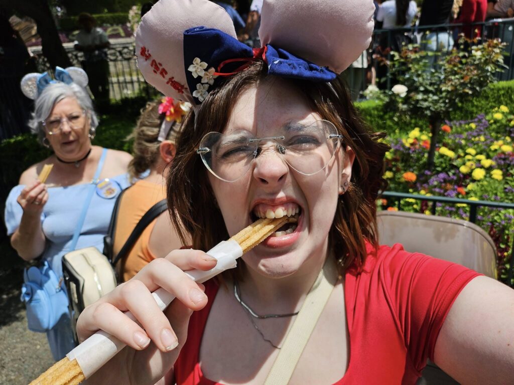 A girl eating a churro which should definitely be on your Disneyland itinerary